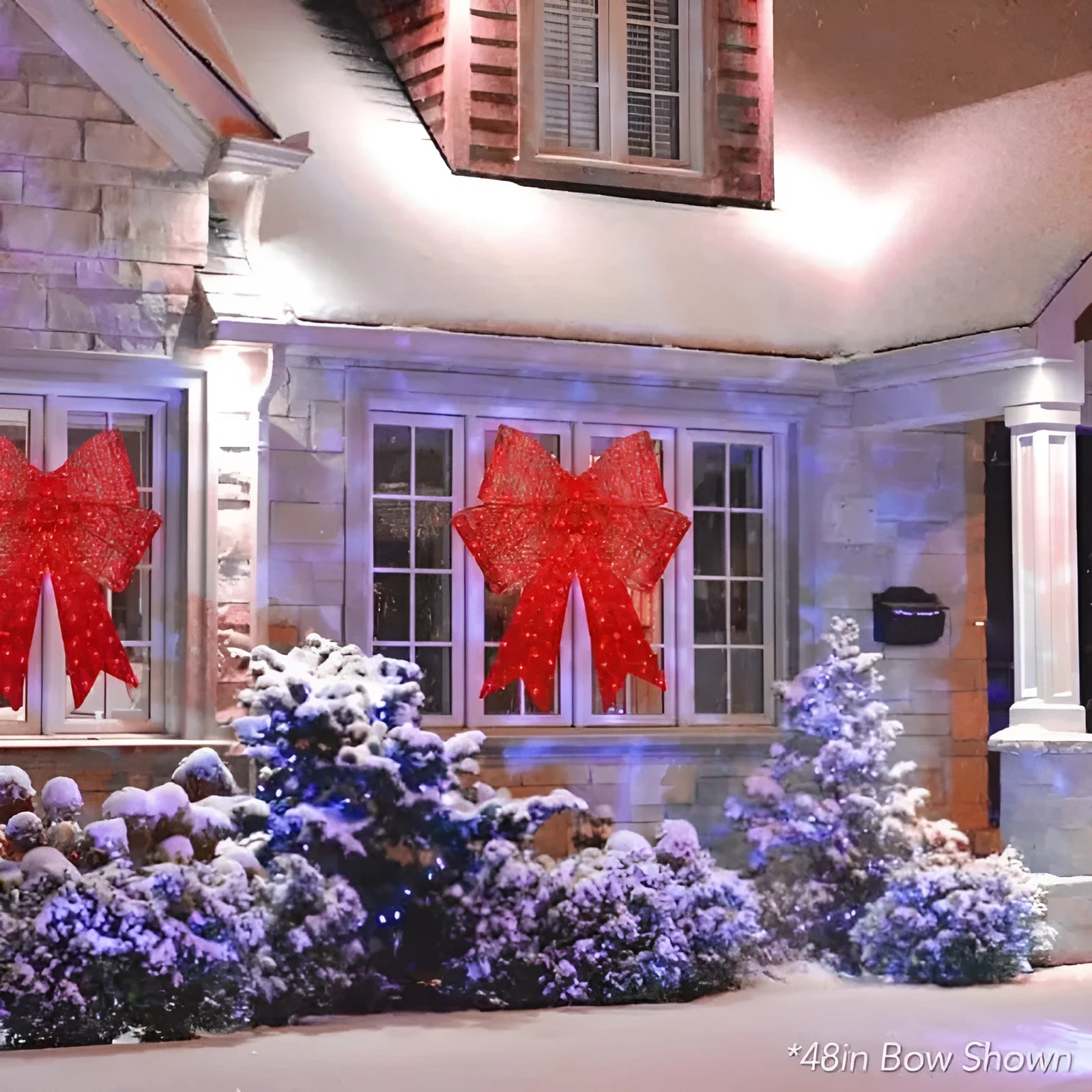 Red satin light up Christmas bowknot on a tree branch with warm glow