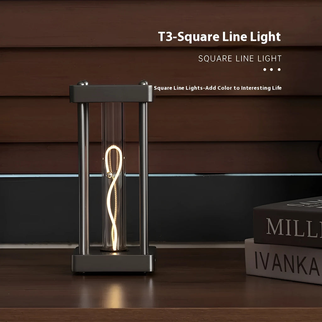 Metallic gray acrylic square night lamp with curved wire on a desk