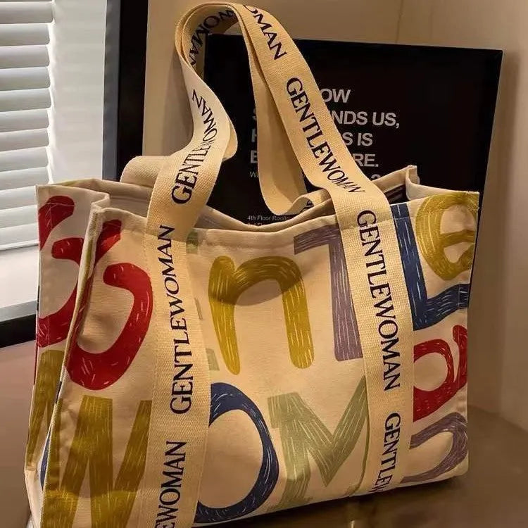 Canvas women's travel tote bag with printed design options including black letters, coloured letters, and pattern styles
