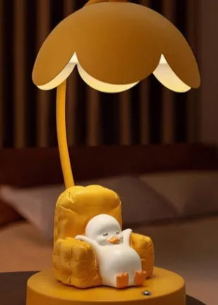 Cute yellow duck plastic night light table lamp with USB cable and gift box on a modern desk