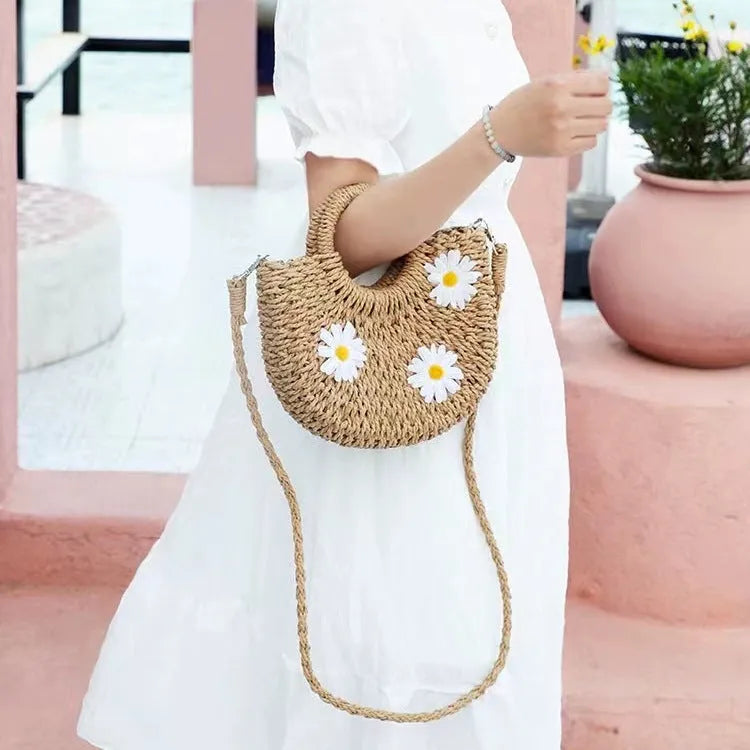Light brown woven straw women's crossbody bag with a daisy pattern design.