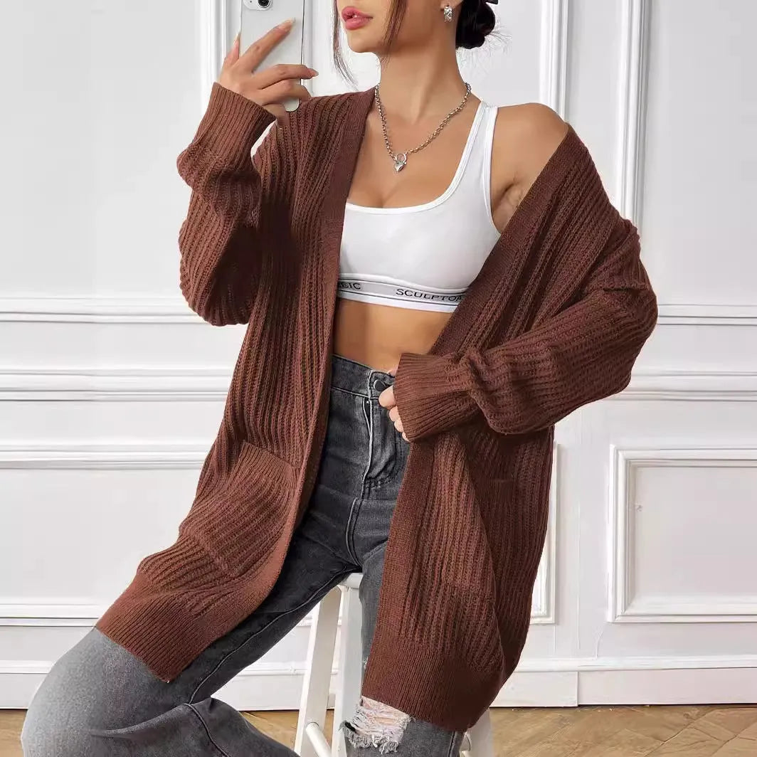 A dark green loose-fit women's cardigan sweater with two front pockets and long sleeves.