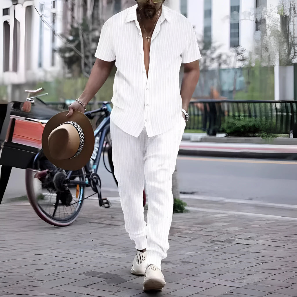 Man wearing a casual short-sleeve shirt and trousers beach suit set in a light blue colour.