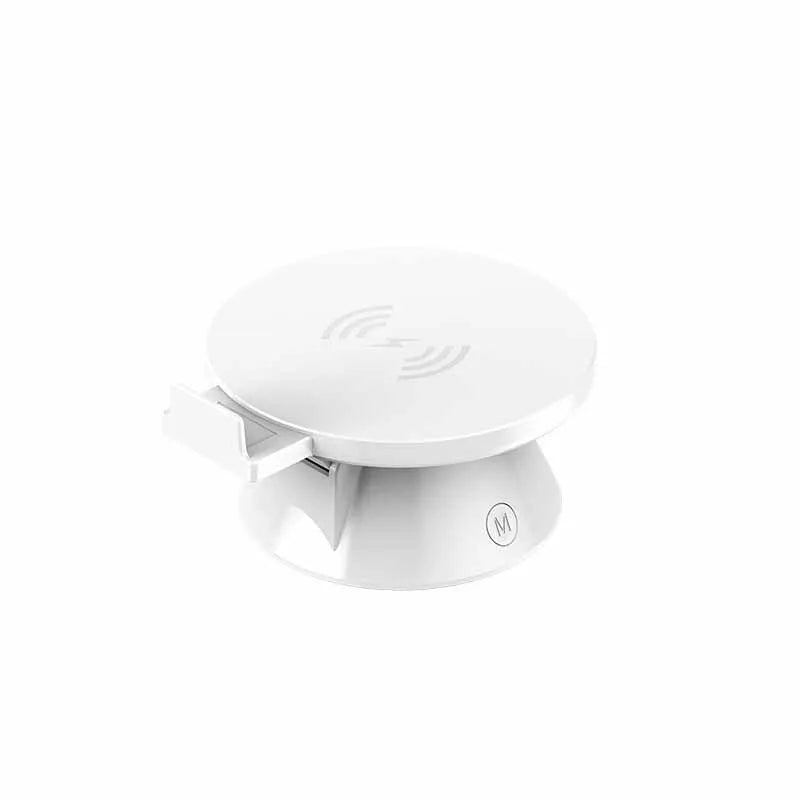 Small plastic stereo wireless mobile phone holder charger in white with Bluetooth speaker and USB cable on desk