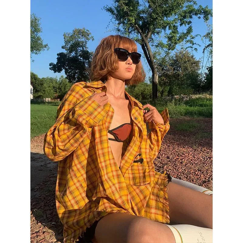 Loose-fit yellow plaid cardigan-style shirt for men and women on a hanger