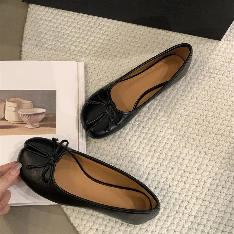 Women's split-toe flat pumps in beige with a round toe and flat rubber sole.