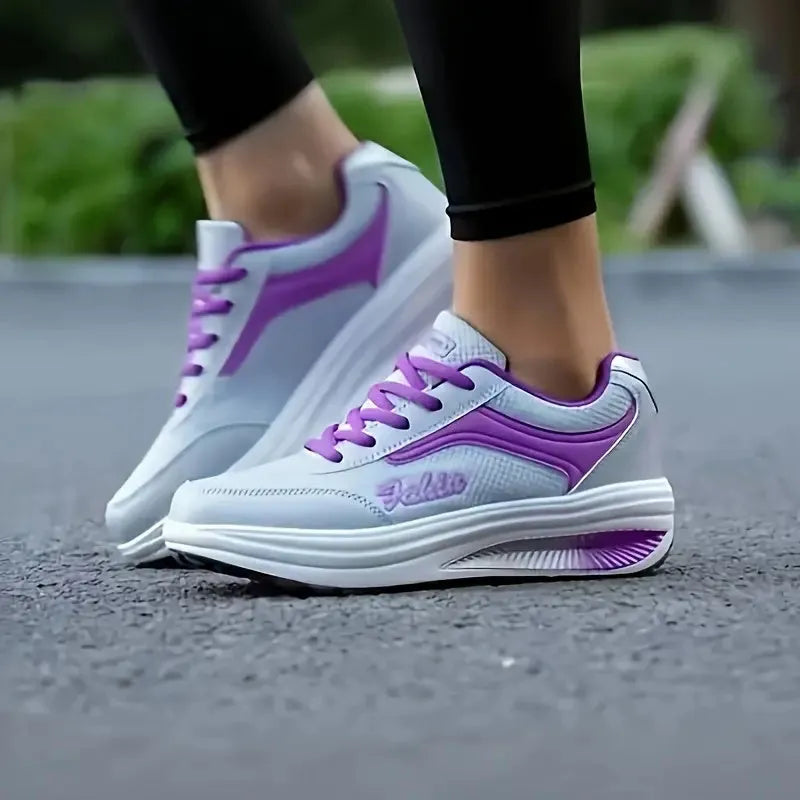 Women's grey powder heelless sports shoes with a middle heel on a plain background