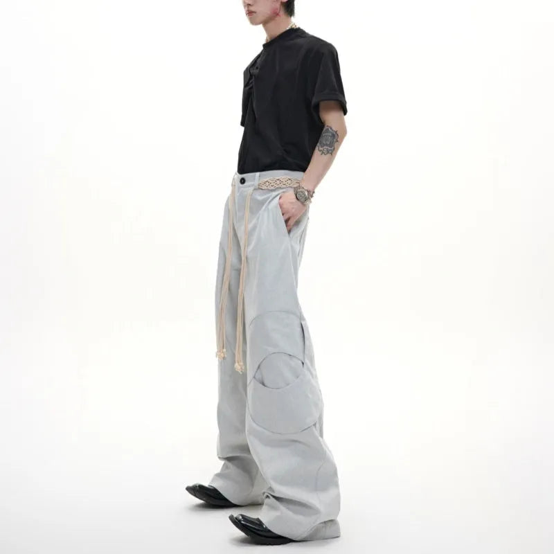 Men's dark blue straight-leg jeans with zipper decorations and tassel details on a loose cotton fit.
