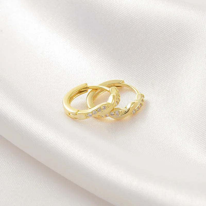 Close-up of women's geometric ear clips with interwoven hemp rope centre in gold tone.