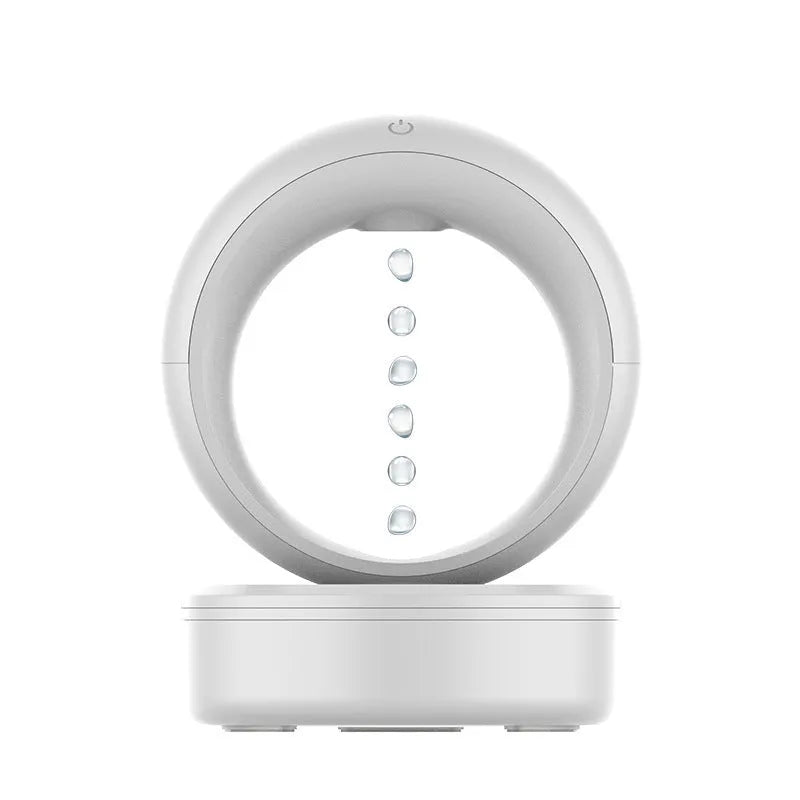 White round anti-gravity air humidifier with levitating water droplets on a desk