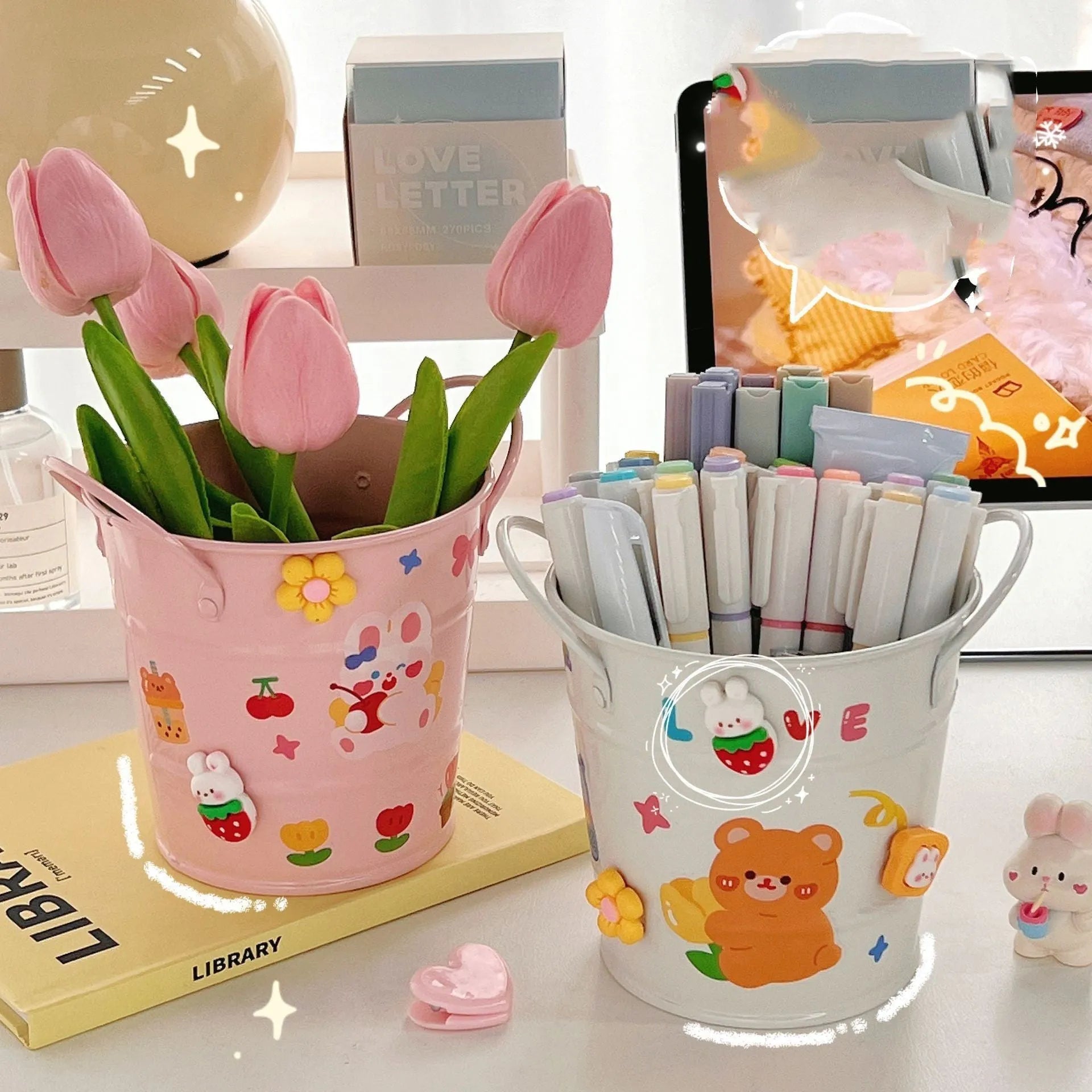 Round metal pen holder in pink with creative iron art design on a wooden desk.