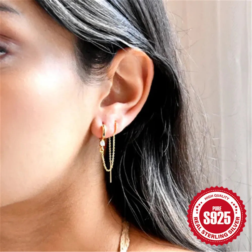 Close-up of a geometric S925 sterling silver clip-on earring featuring a diamond flower and a delicate gold-plated chain tassel.