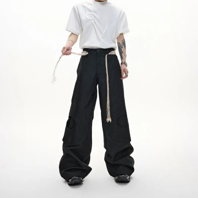 Men's dark blue straight-leg jeans with zipper decorations and tassel details on a loose cotton fit.