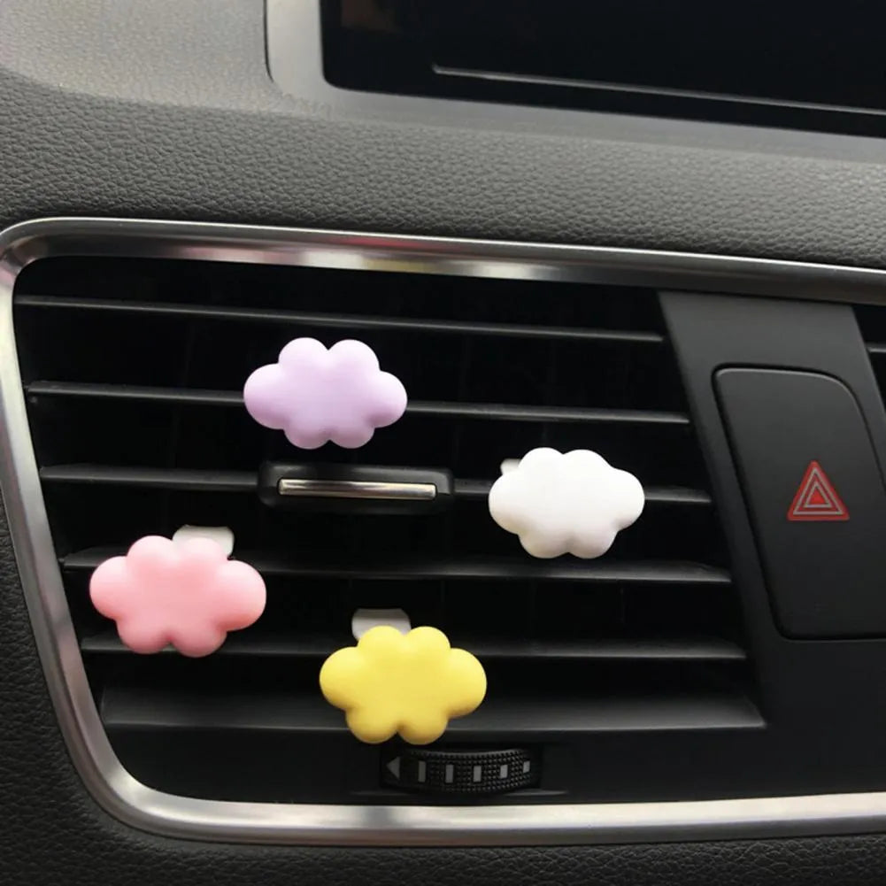 Resin cartoon-style car fragrance clip attached to a vehicle air vent.