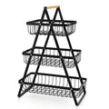 Black detachable iron double-layer fruit basket with a wooden carry handle on a tabletop.