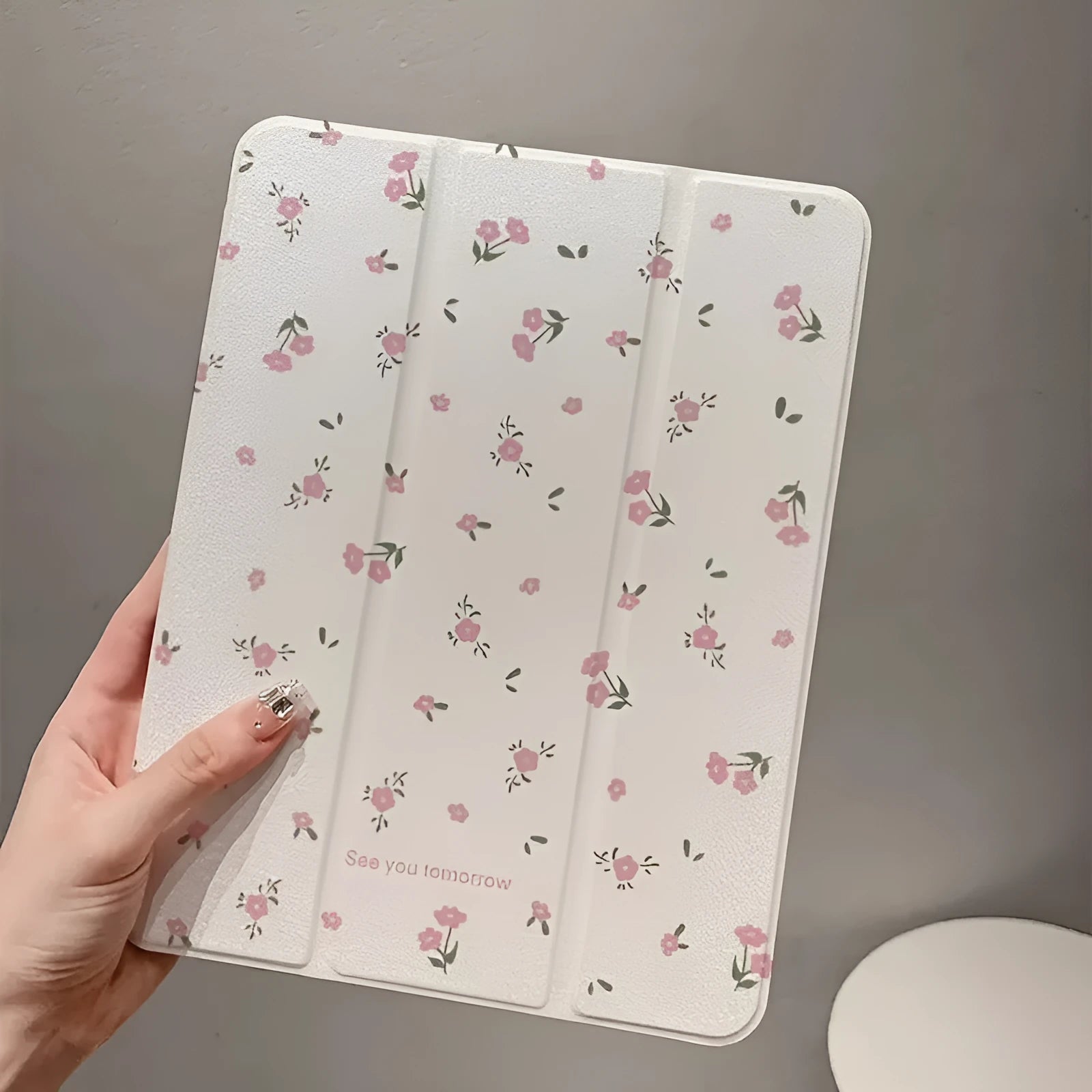 Transparent floral patterned iPad case folded into standing position showing magnetic closure and port cutouts