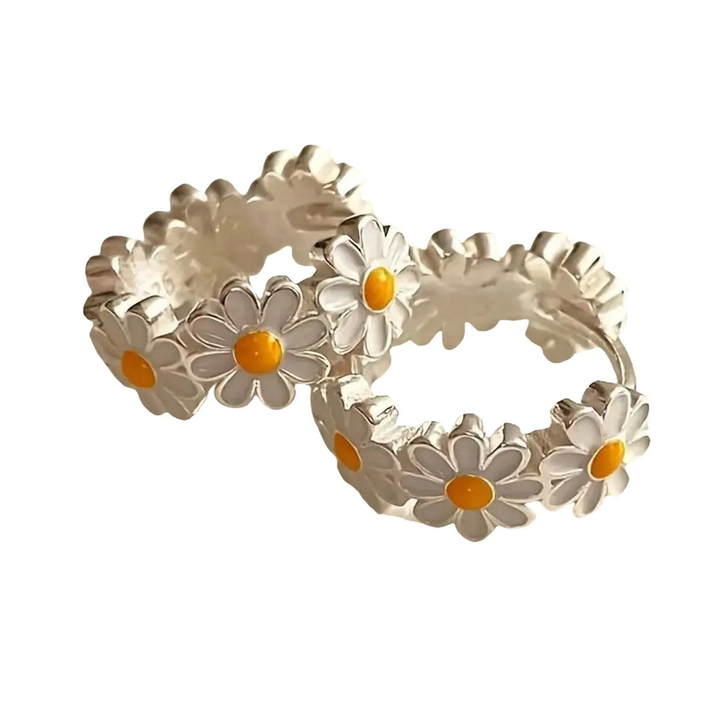 White electroplated copper daisy flower earrings with platinum gem inlay on white background