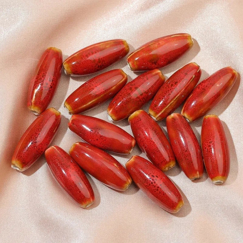Assorted high-temperature fired ceramic bullet beads in pink, yellow, blue, red, coffee, green, orange, and mixed glaze colours.