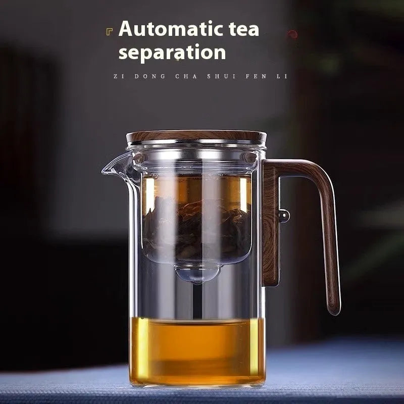 Glass teapot with wooden handle showing magnetic tea separation button and drip-free spout.