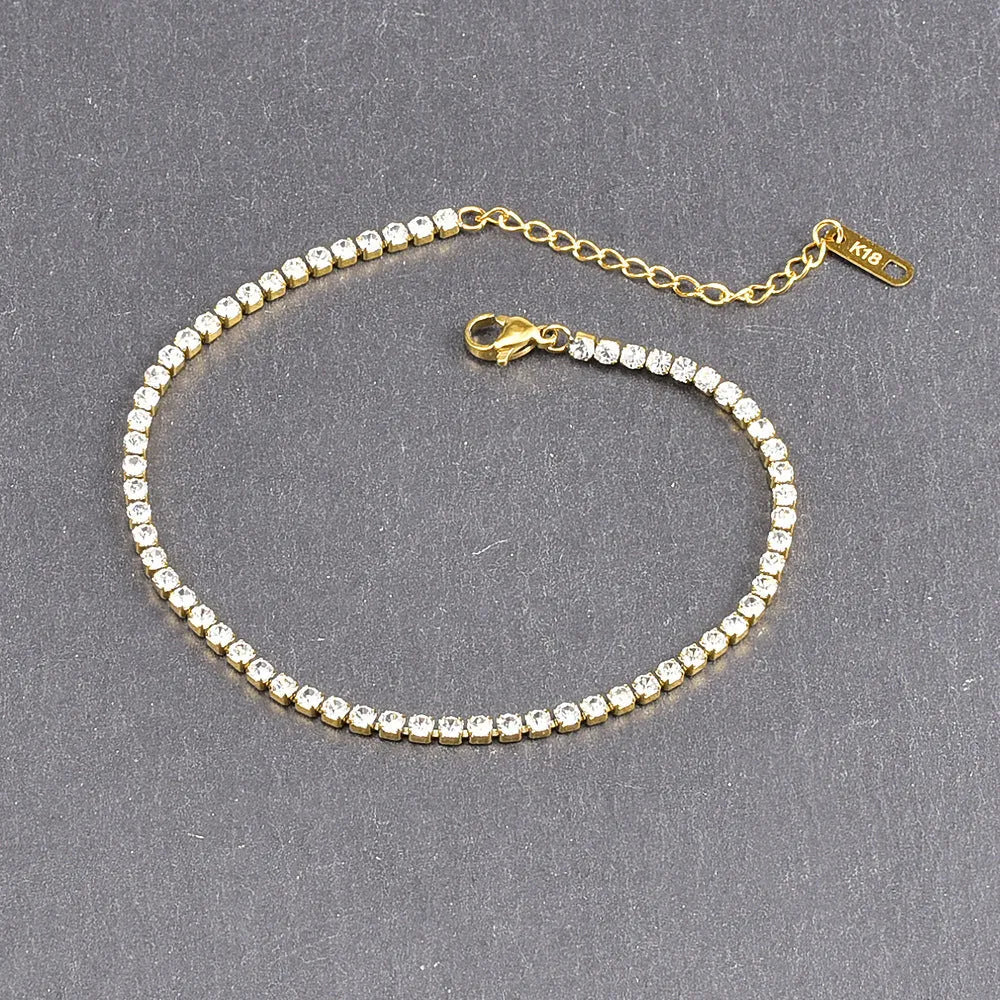 Gold titanium steel anklet with small fruit-shaped pendant and adjustable tail chain on bare ankle