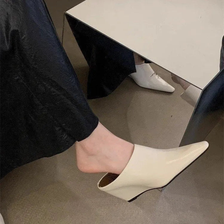 Women's black closed toe wedge half slippers showing PU upper material and wind wedge sole design