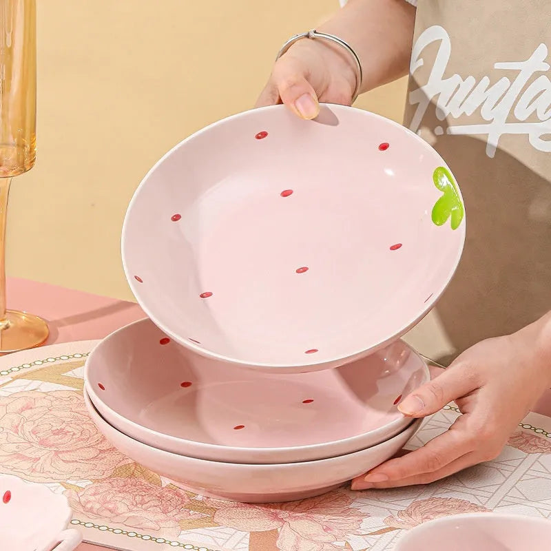 Creative strawberry-themed porcelain dinnerware set with fish plate, flower bowls, and straw hat plate.