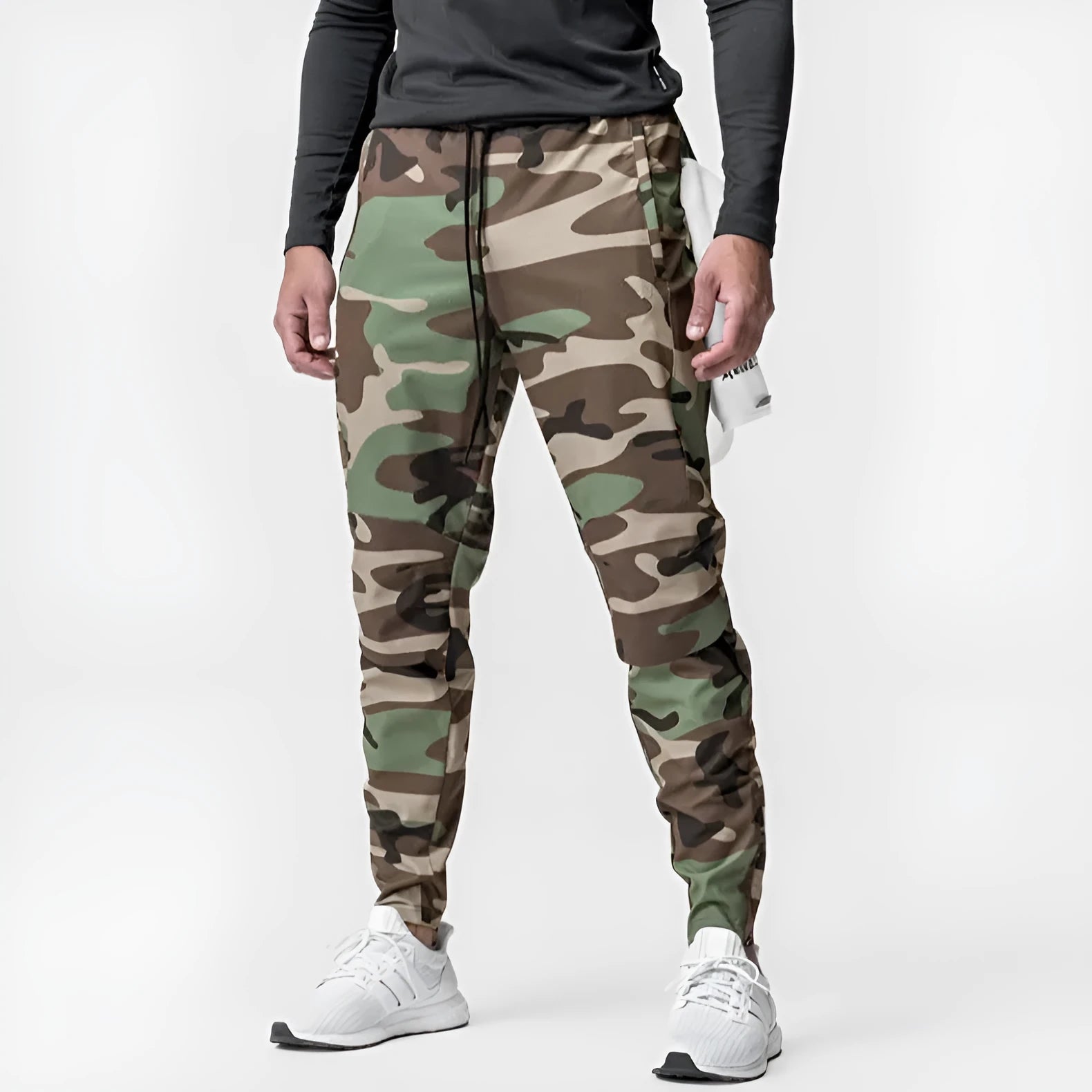 Man wearing dark grey loose-fit ankle-tied fitness trousers made of quick-drying polyester during a workout.