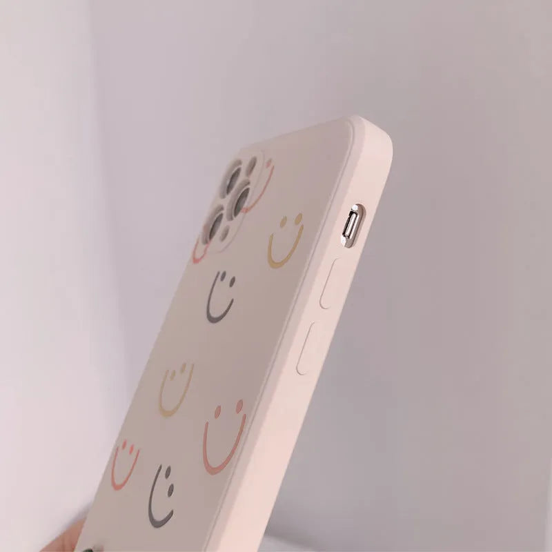 Painted silicone iPhone case showing smiley, rainbow, and watercolour design options
