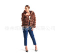 A woman modelling a loose-fitting, hooded artificial fur coat in a street fashion style.