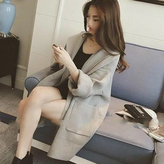 Plus size woman wearing a thin grey cotton coat with lace detail, loose fit long sleeves.