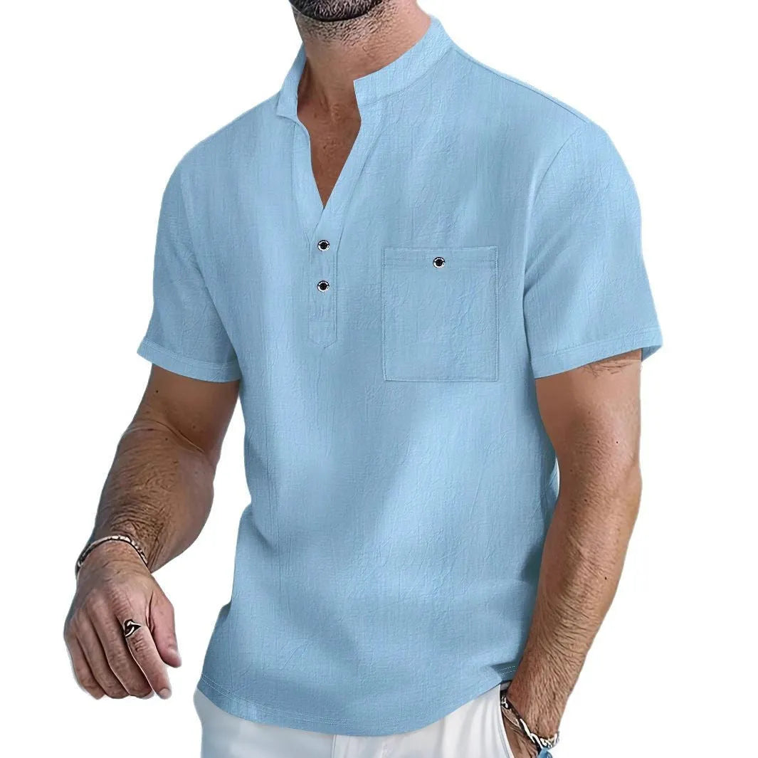 Man wearing a light blue stand collar linen blend t-shirt with short sleeves and a loose fit.