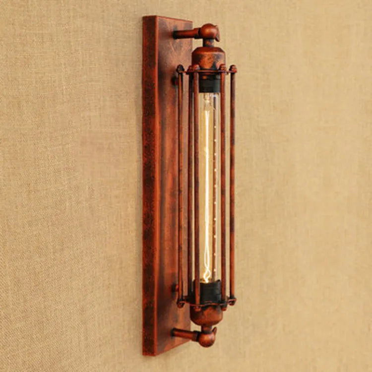Industrial retro flute shaped iron wall lamp in an antique finish, shown mounted on a wall.