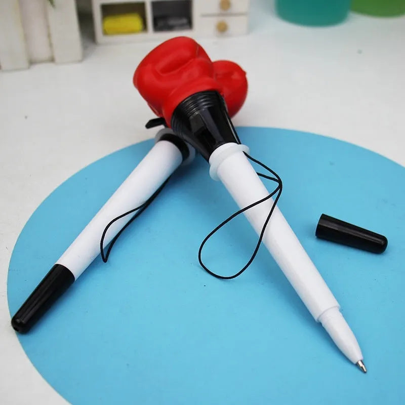 Set of four black creative pressure relief pens with boxing figure press-to-eject mechanism.