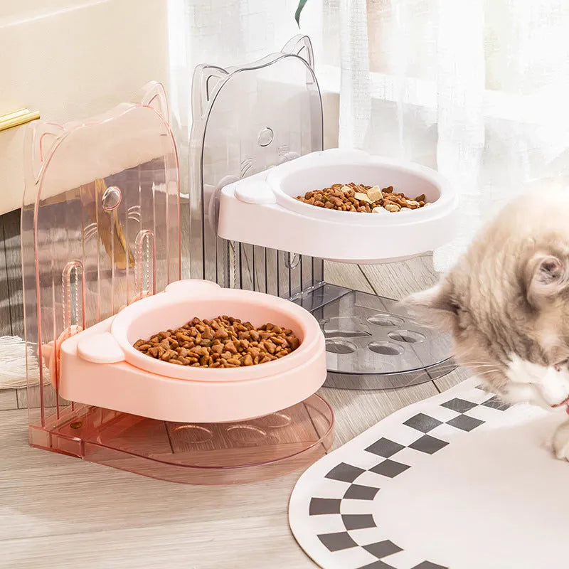 Grey adjustable height cat feeding bowl with anti-spill neck protection hanging on cage bars.