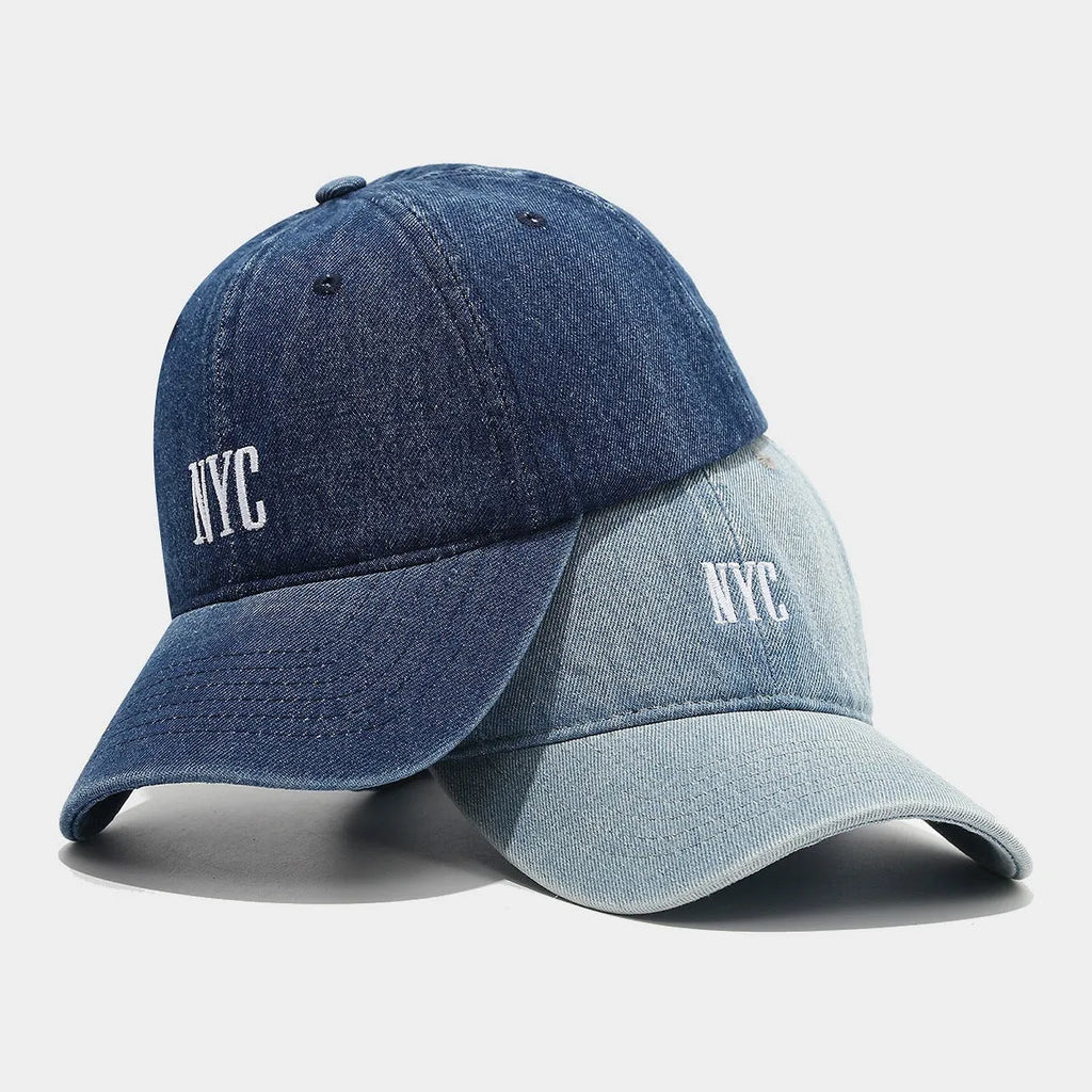 Adjustable denim peaked cap with a dome crown and a large English letter design on the front.