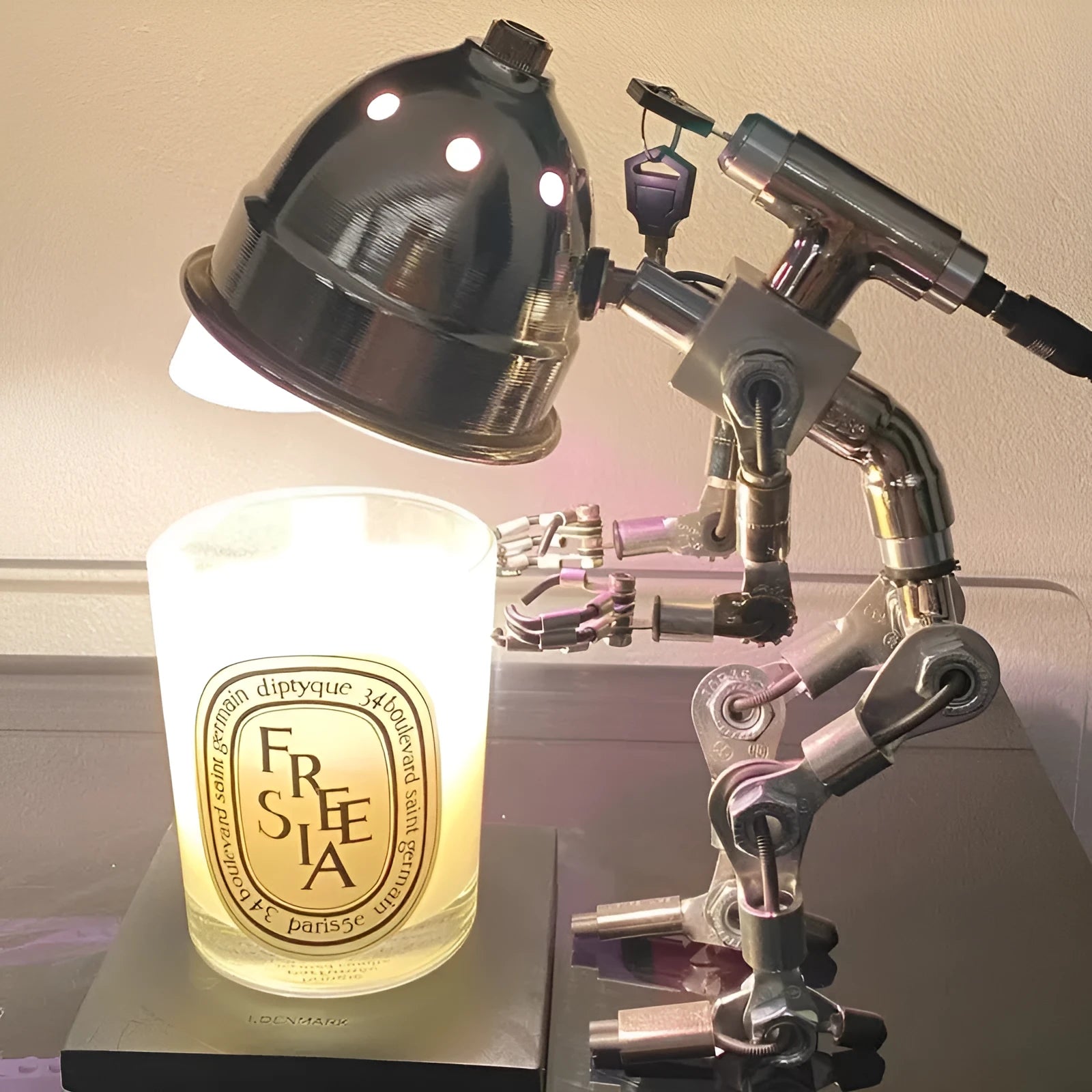 Silver copper robot-shaped decorative mood lamp on a desk.