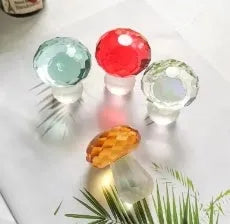 Colourful geometric crystal mushroom decoration in transparent, green, red, or yellow, 40mm by 53mm.