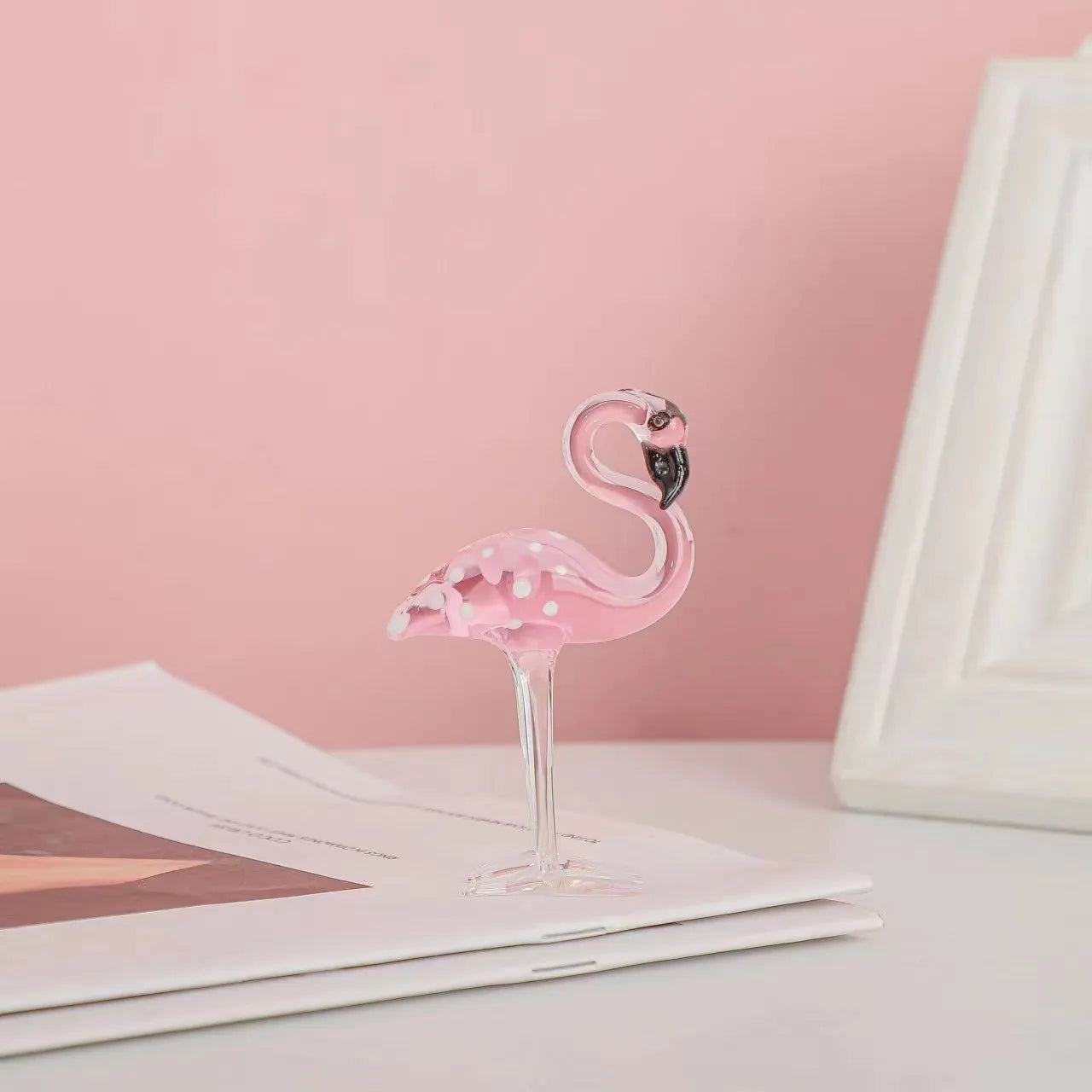 Pink crystal flamingo decorative ornament on a table for modern home decor.