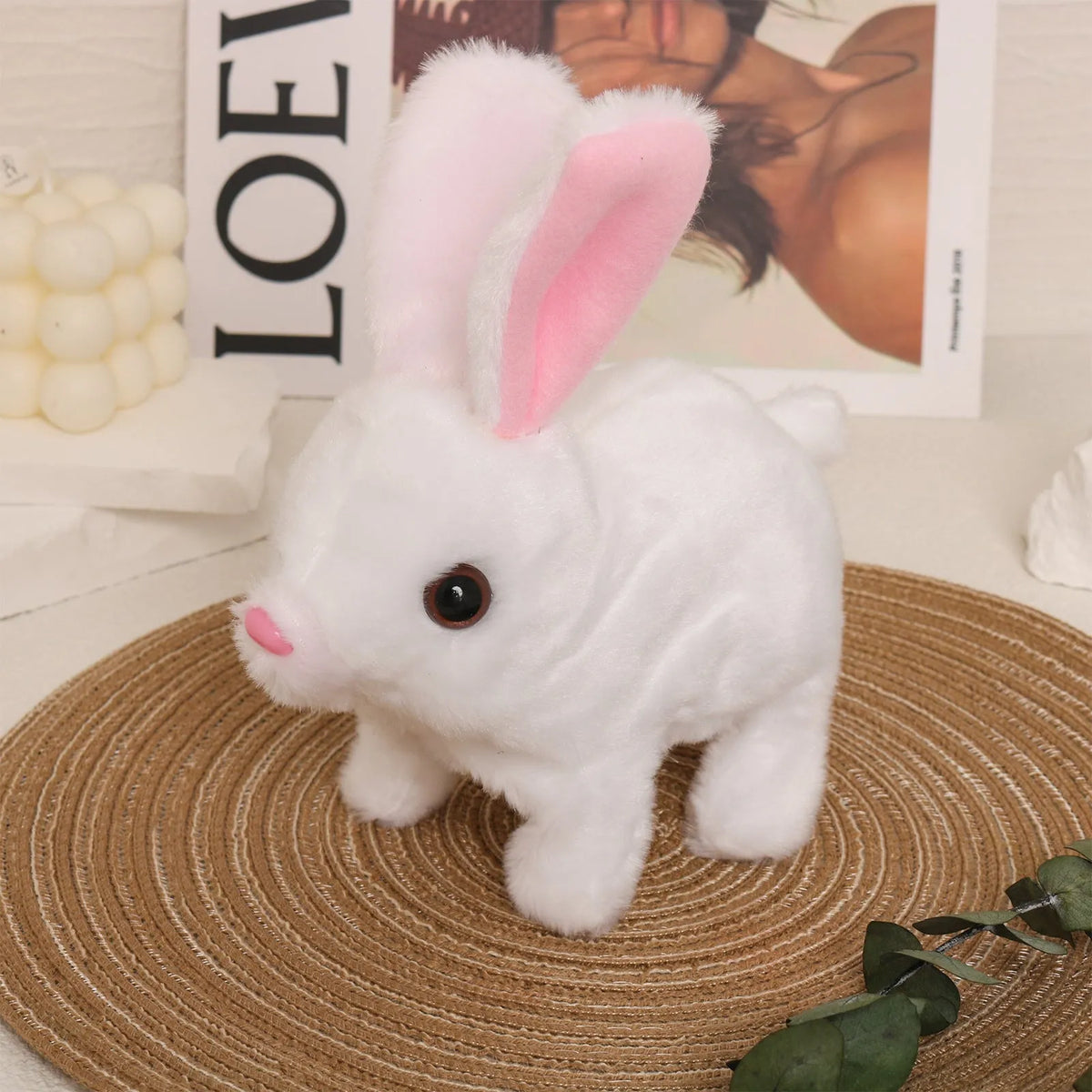 Electric realistic rabbit plush toy in plush material with carrot accessory on white background