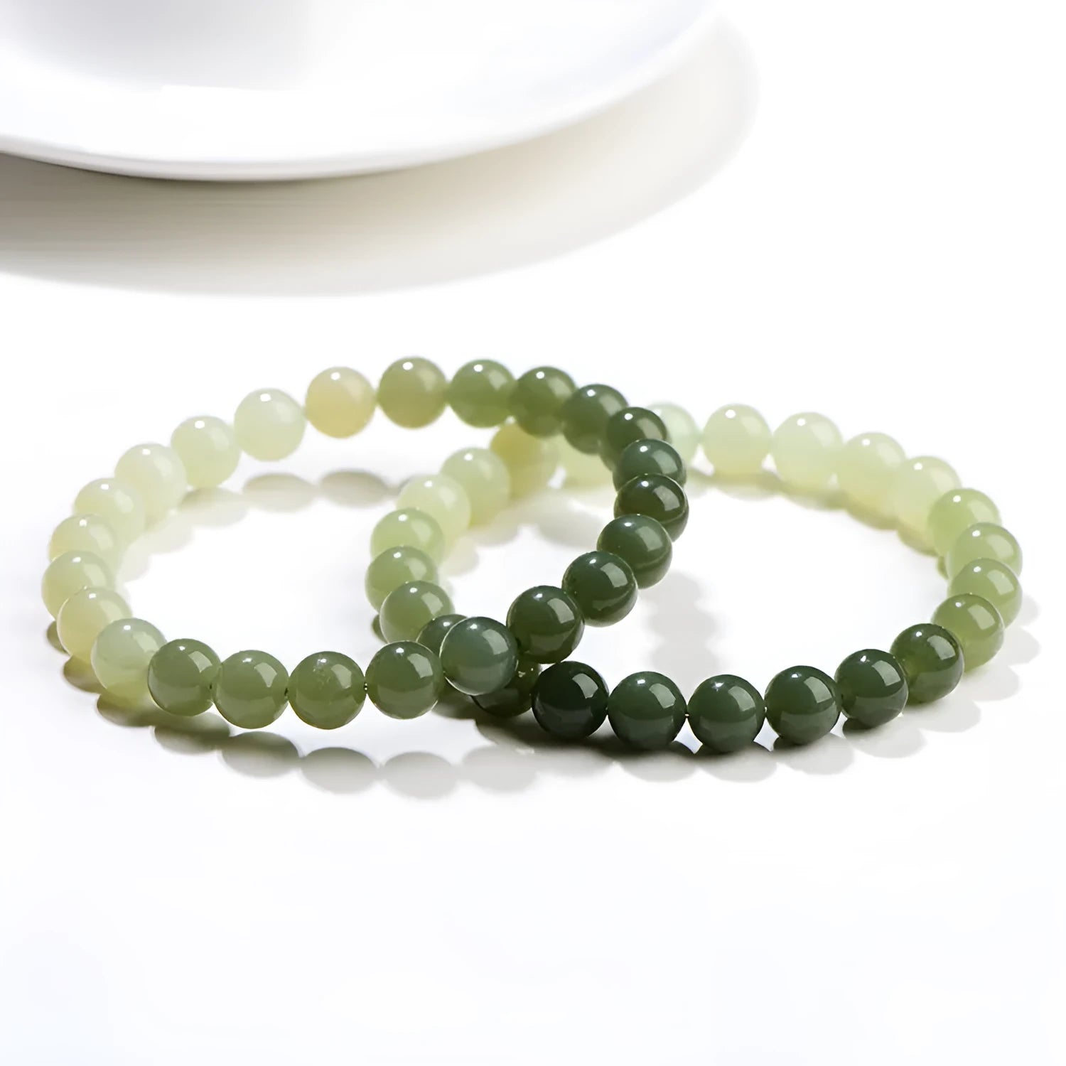 Natural Hetian jade bracelet with gradient clear water colour beads on a wrist.
