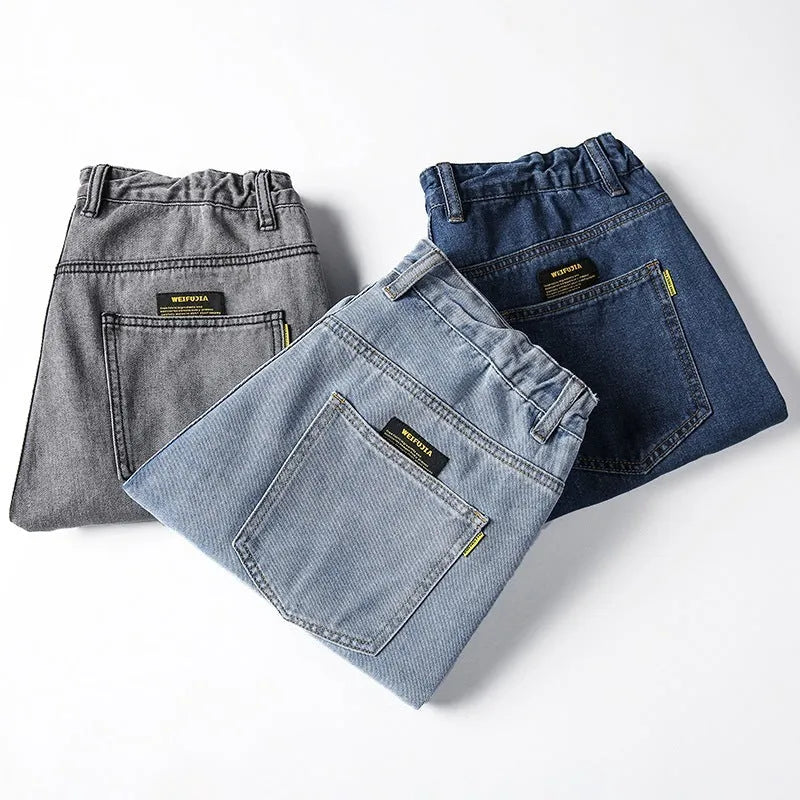 Man wearing dark blue loose straight-leg cotton jeans with a simple design and zipper fly.