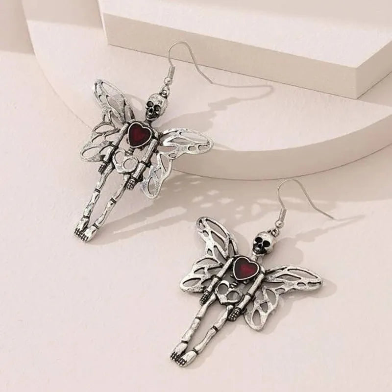 Pair of silver-coloured alloy earrings with exaggerated skull design on white background