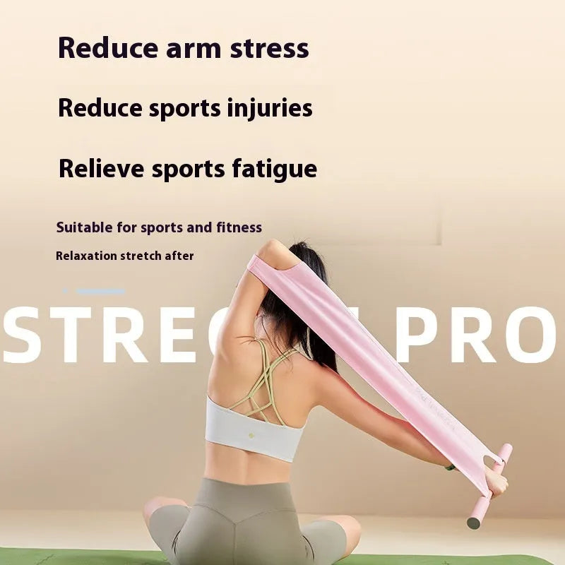 Grey and pink yoga stretching tool for back flexibility and hip opening exercises on a mat.