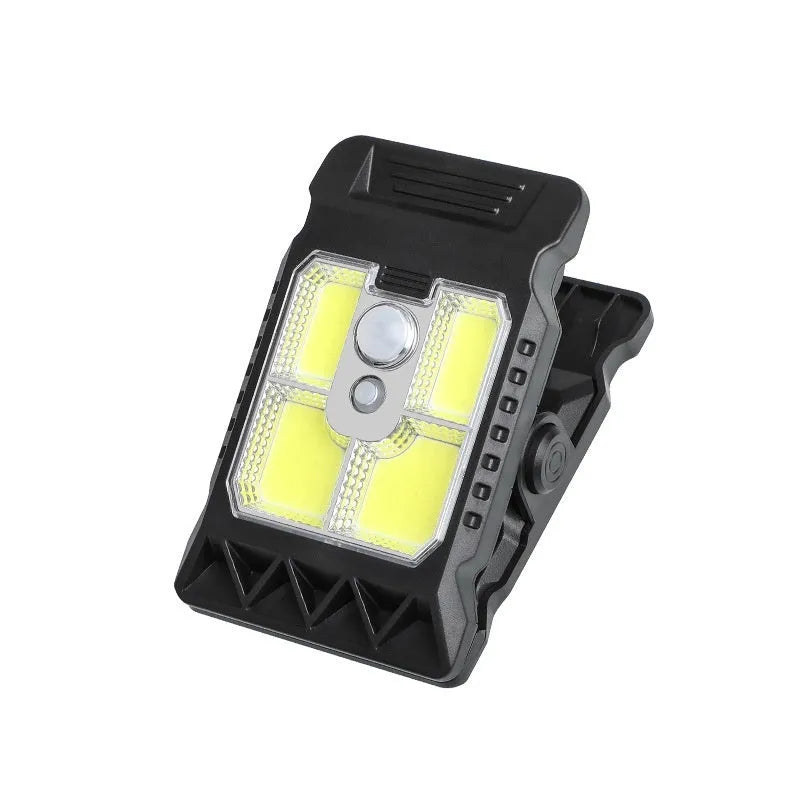 Compact white ABS plastic LED clip lamp with motion sensor, shown clipped to a shelf edge.
