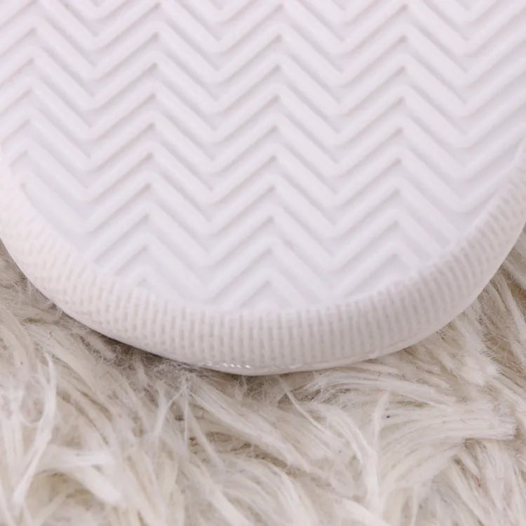 White fluffy slippers with cartoon pattern, rubber soles, and artificial wool lining