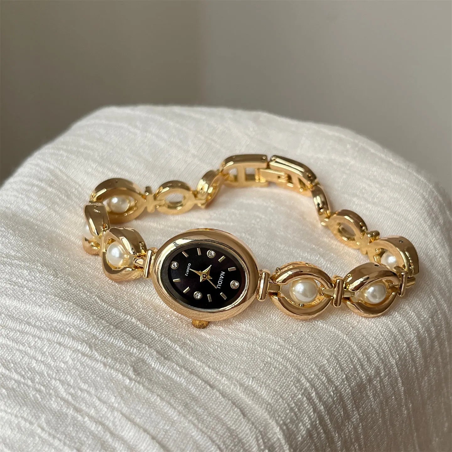 Women's quartz fashion bracelet watch with alloy case and pointer display, gold strap with white surface