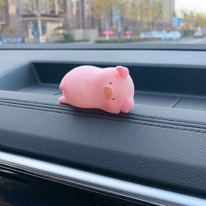 A hard resin cartoon pig car dashboard ornament in one of eight available decorative styles.