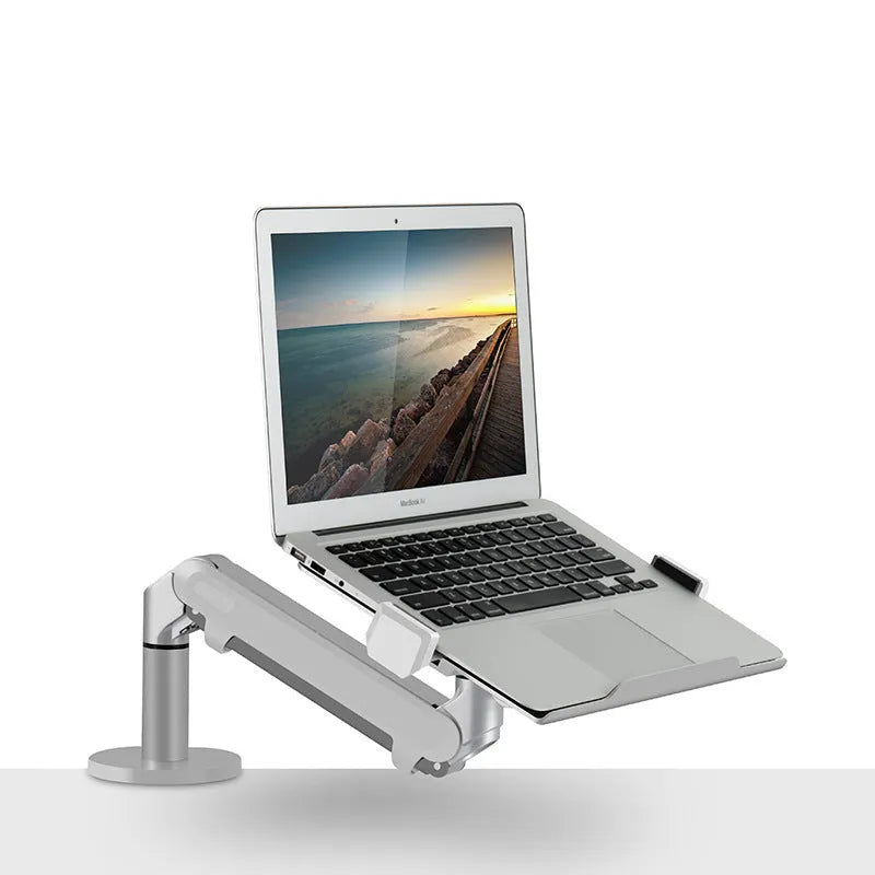 Silver aluminium laptop stand with an adjustable arm bracket on a wooden desk.