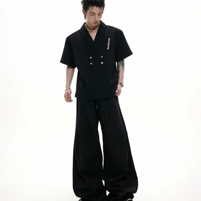 Men's dark grey V-neck sports suit with padded shoulders, metal details, and cotton shorts laid flat.