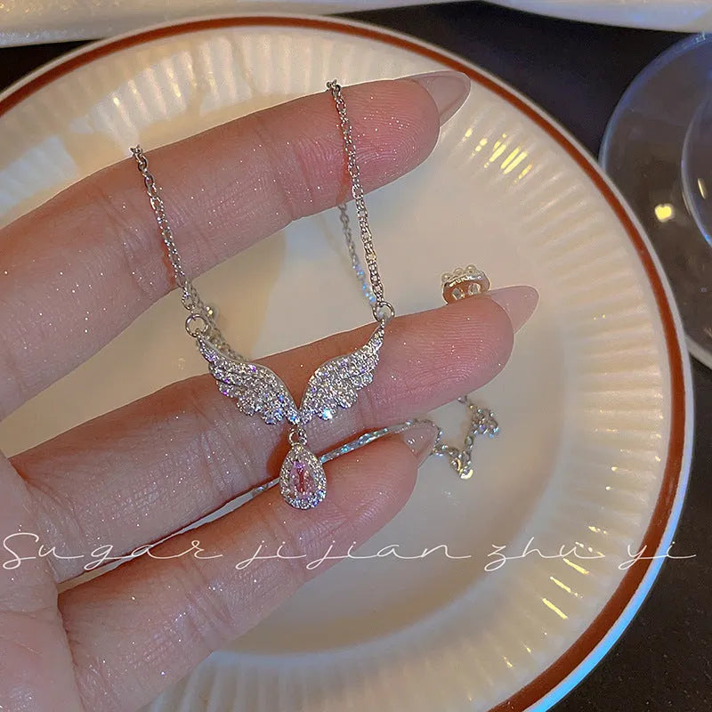 Simple sterling silver necklace with a geometric fishtail or angel wing pendant on an O-ring chain.